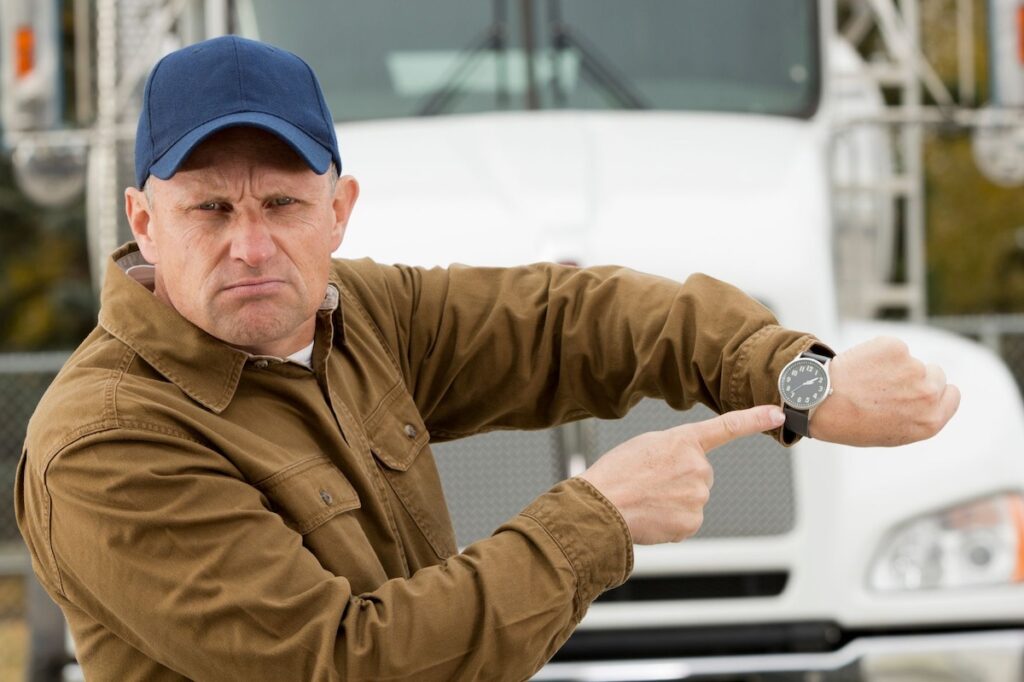 Contractor with semi truck in background pointing at watch
