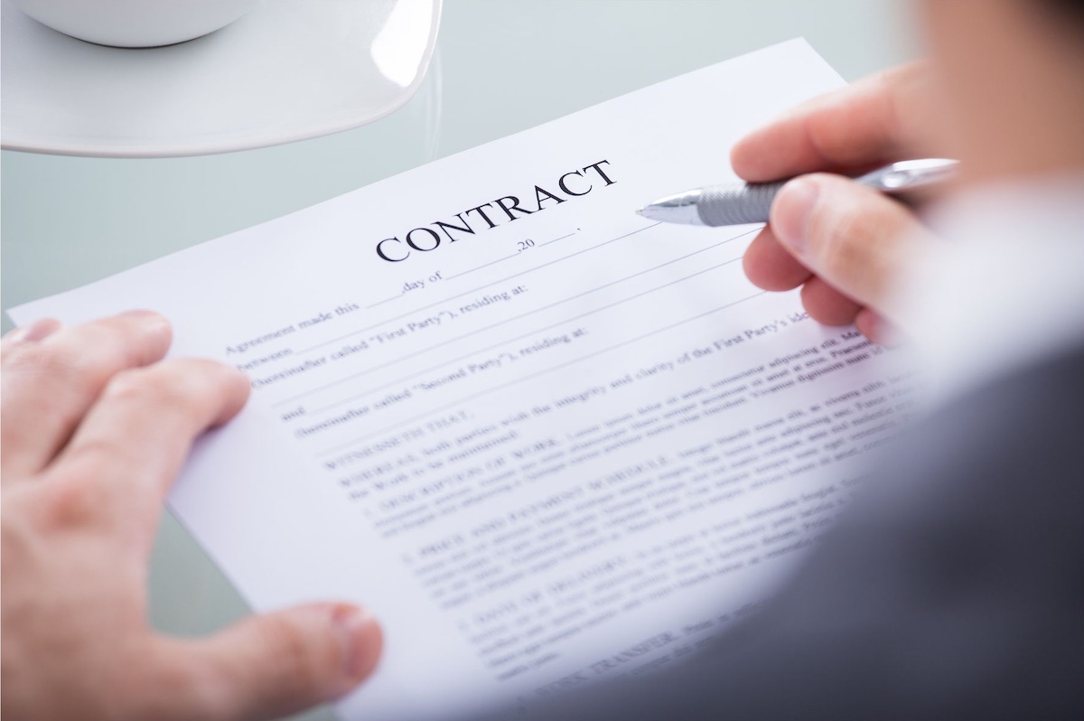 Contract and person with pen