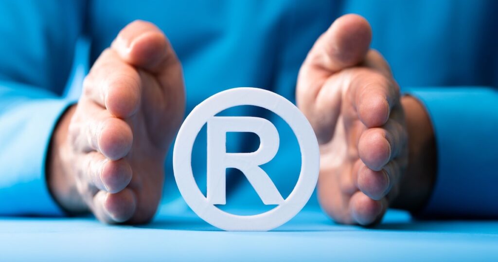 Registered symbol between two hands